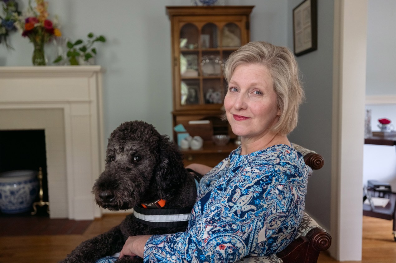 A photo of a woman seated with a dog.